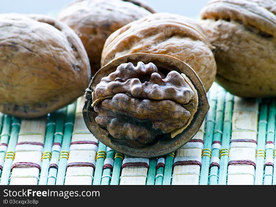 Close-up of group of walnuts. One is opened.