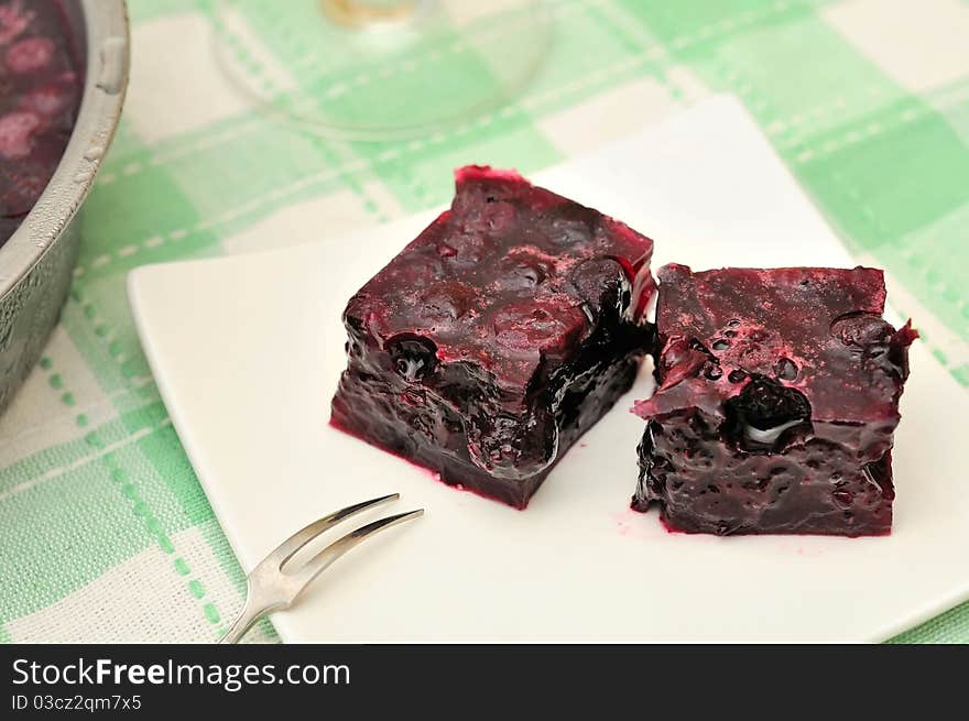 Red jelly cubes on white plate. Made from healthy fruits and berries. Red jelly cubes on white plate. Made from healthy fruits and berries.