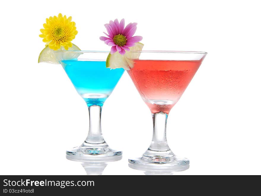 Tropical martini Cocktails row with vodka, light rum, gin, tequila, blue curacao, lime juice, lemonade, lemon slice and fresh summer flowers in martinis cocktail glass on a white background. Tropical martini Cocktails row with vodka, light rum, gin, tequila, blue curacao, lime juice, lemonade, lemon slice and fresh summer flowers in martinis cocktail glass on a white background