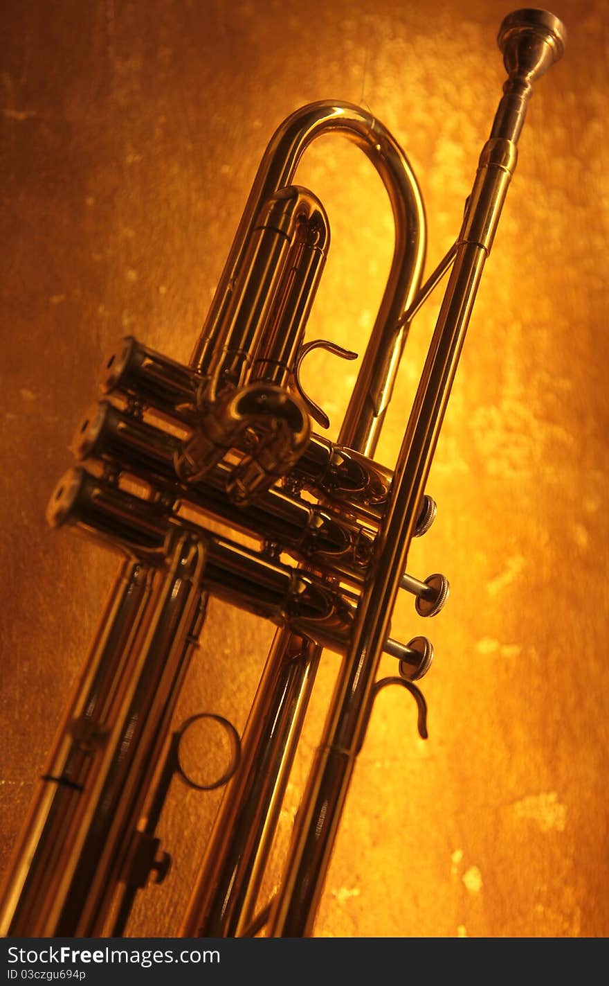 Brass trumpet horn on a golden background. Soft light and focus photograph.