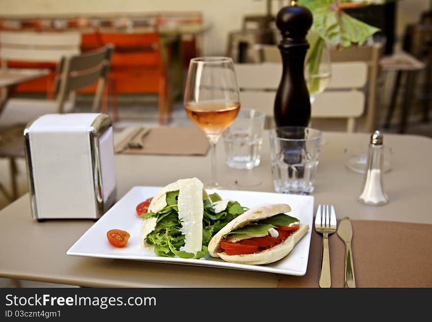 Panini salad and wine on an outdoor table restaurant