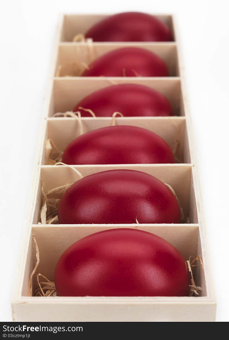 Red eggs in a wooden box on a white background. Red eggs in a wooden box on a white background