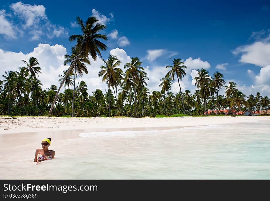 Beautifull women and Green palms on white sand beach under blue sky near sea