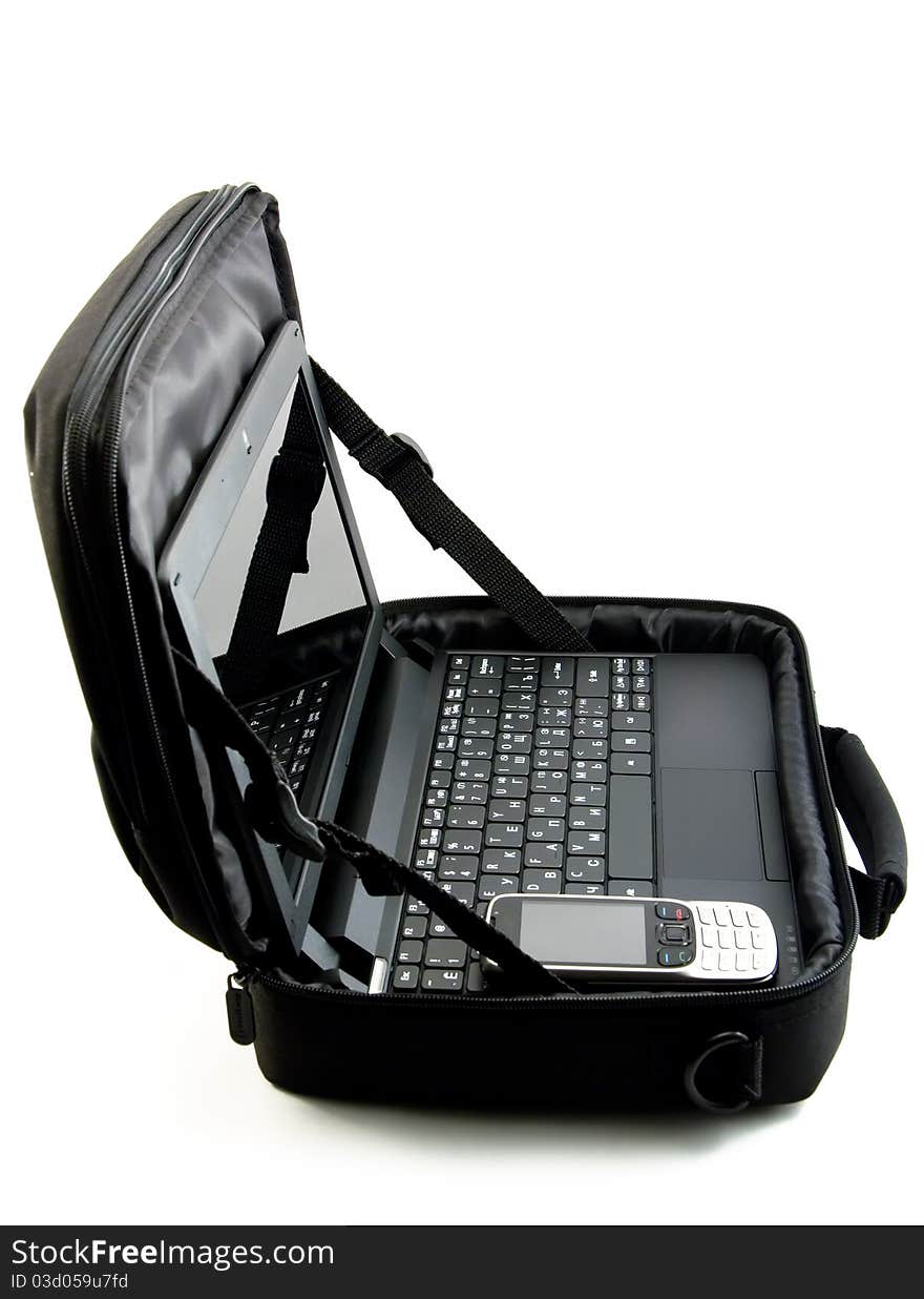 The laptop lies in an open bag together with phone. The laptop lies in an open bag together with phone