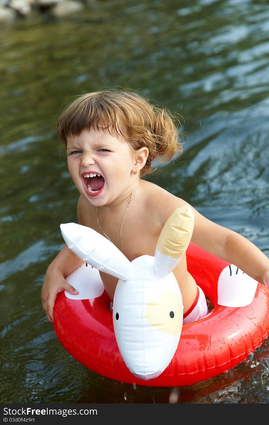 Little girl swims in sea in an red life preserver. Little girl swims in sea in an red life preserver