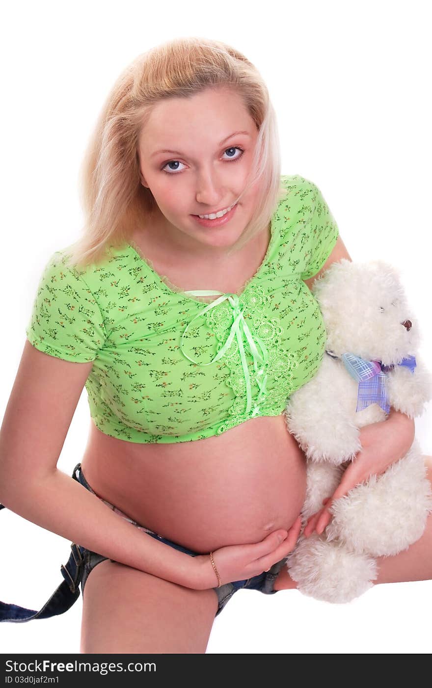 Cute pregnant girl sitting with teddy bear