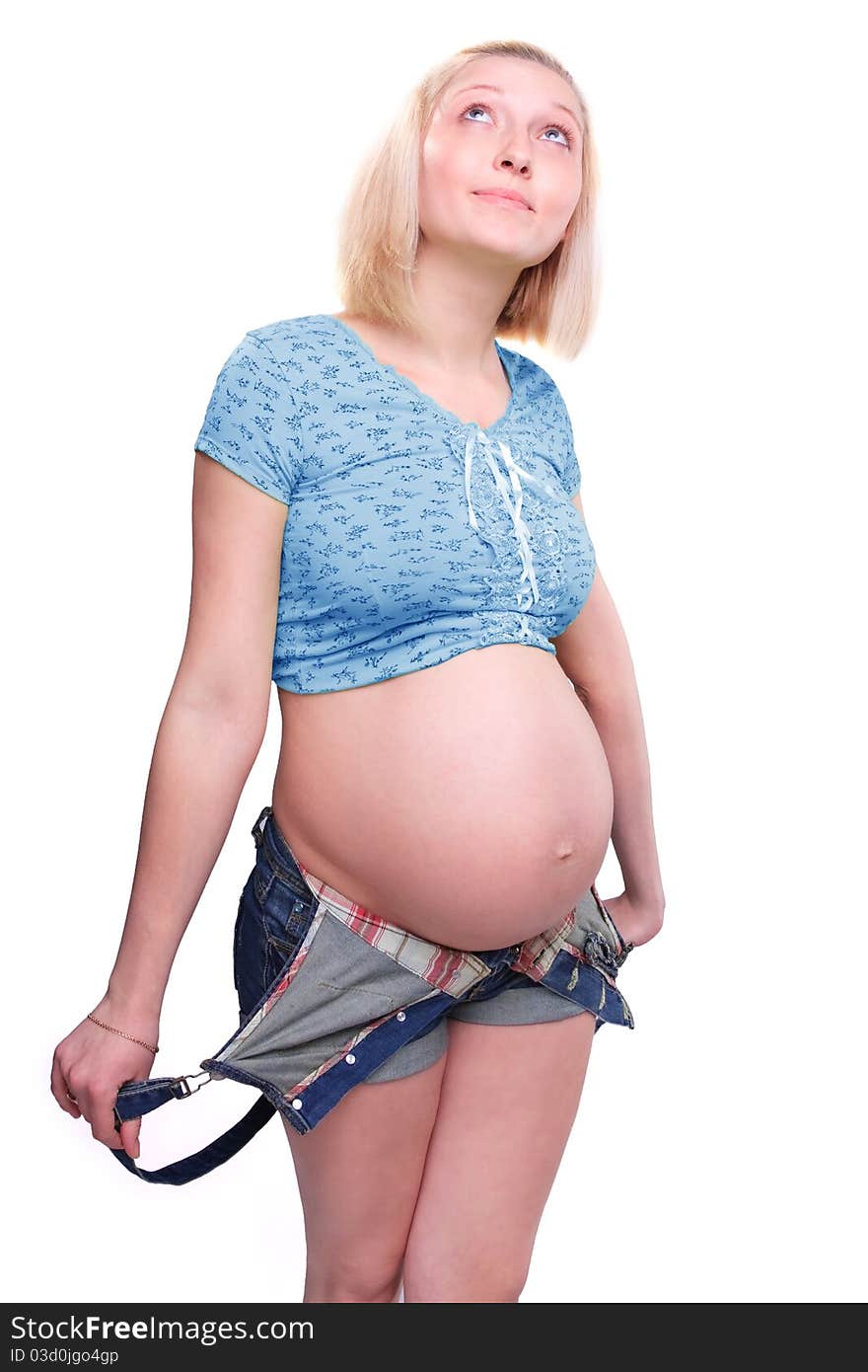 Young pretty pregnant woman posing in jeans overalls