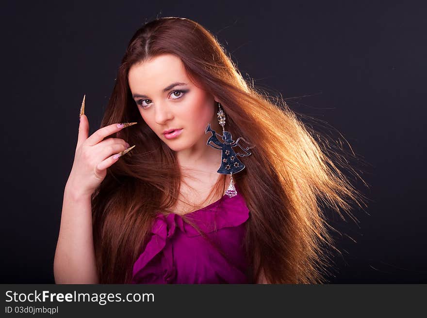 Beautiful long-haired brunette in a dress of fuchsia with sparkle earring. Beautiful long-haired brunette in a dress of fuchsia with sparkle earring