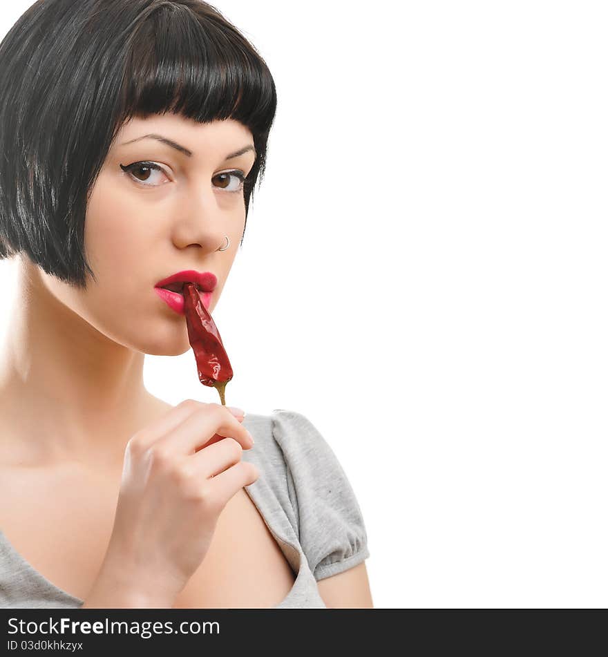 Close up shot of a beautiful woman with red chili in mouth isolated on white background