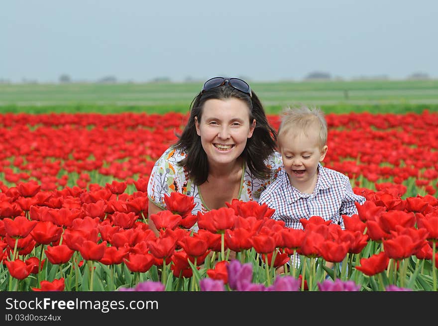 Mother with son in the red tulips field. Mother with son in the red tulips field