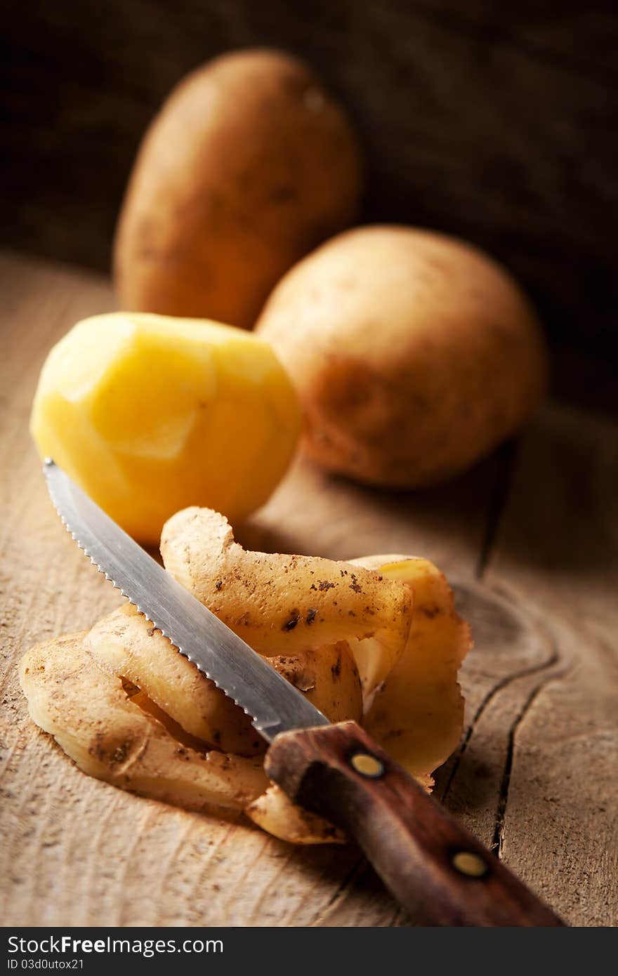 Potato And Knife On A Rustic Table