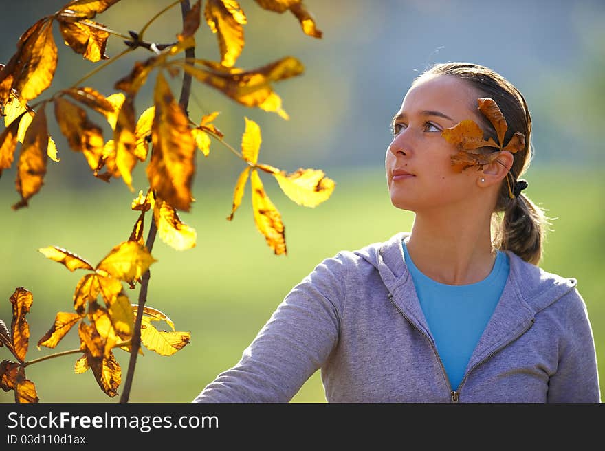 Young girl throws leaves in park