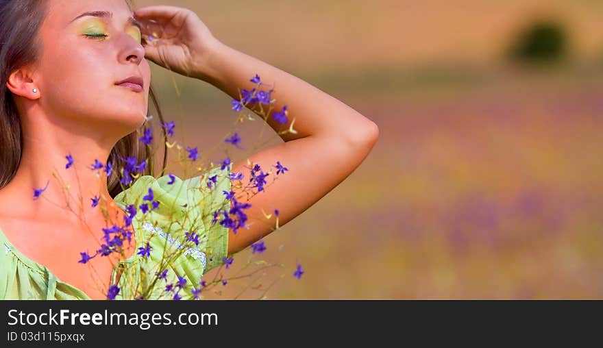 Young beautiful woman on field in summer