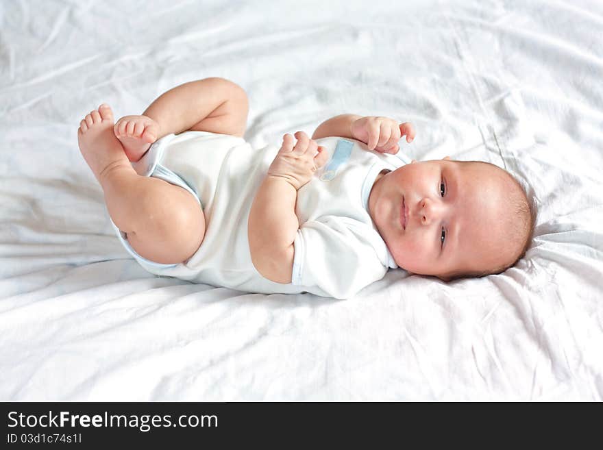 Cute Little Child Is Lying On The Sheet