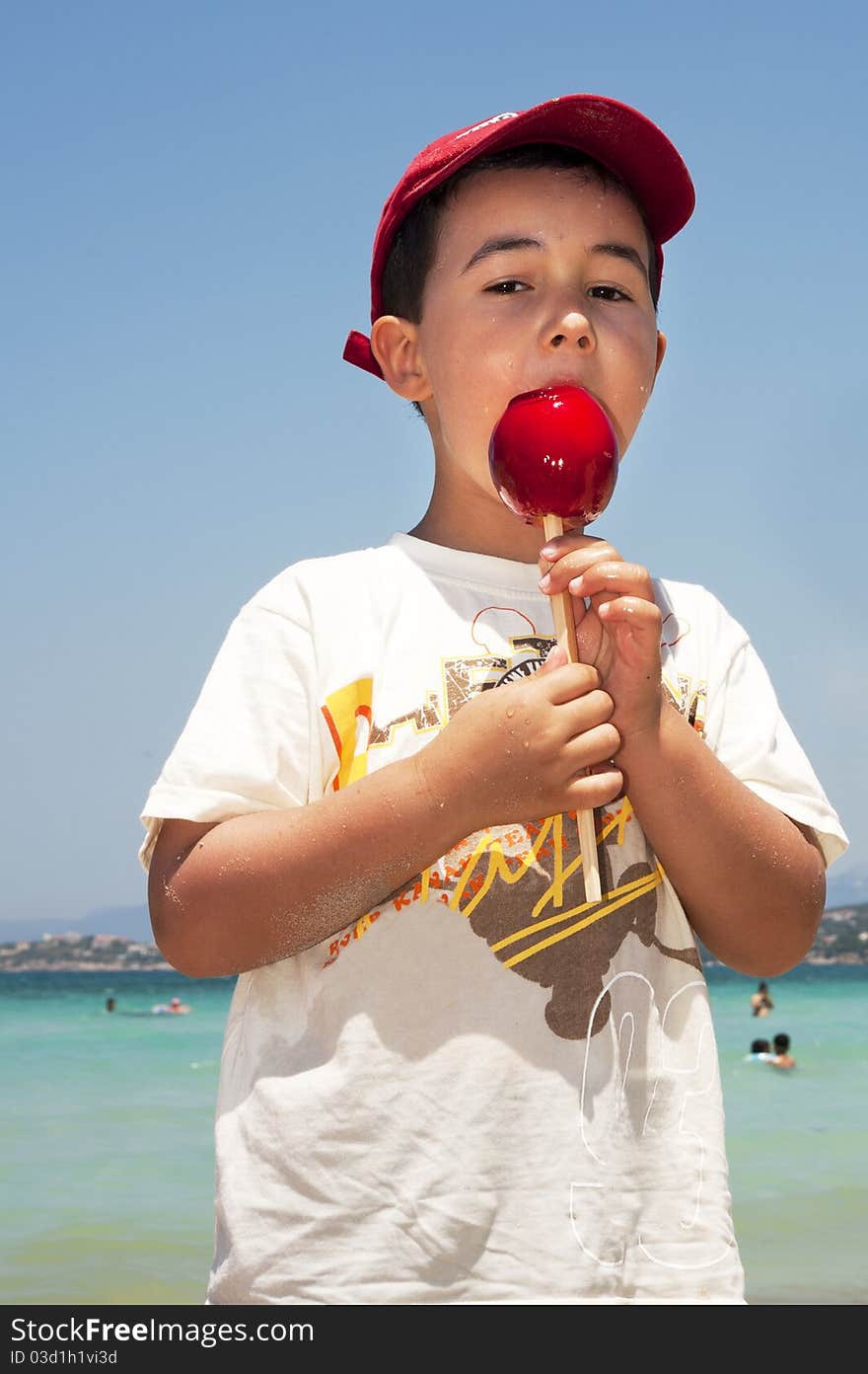 Boy enjoying bright red candy apple. Boy enjoying bright red candy apple