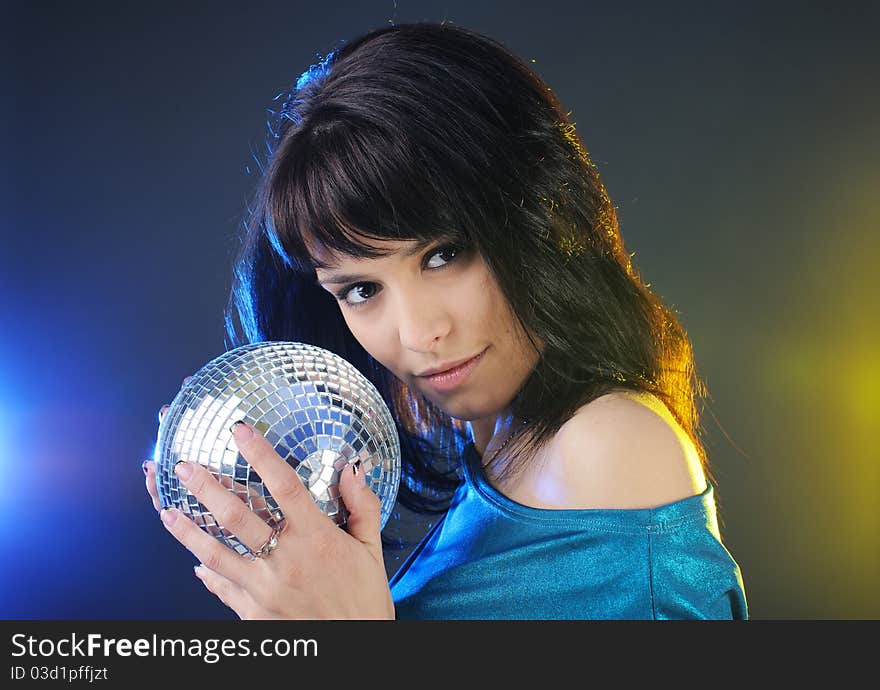 Portrait of beautiful young brunette with disco ball