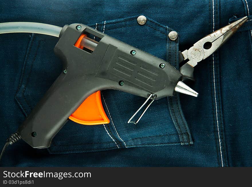 Blue jeans and tools in pocket (glue gun and plier).