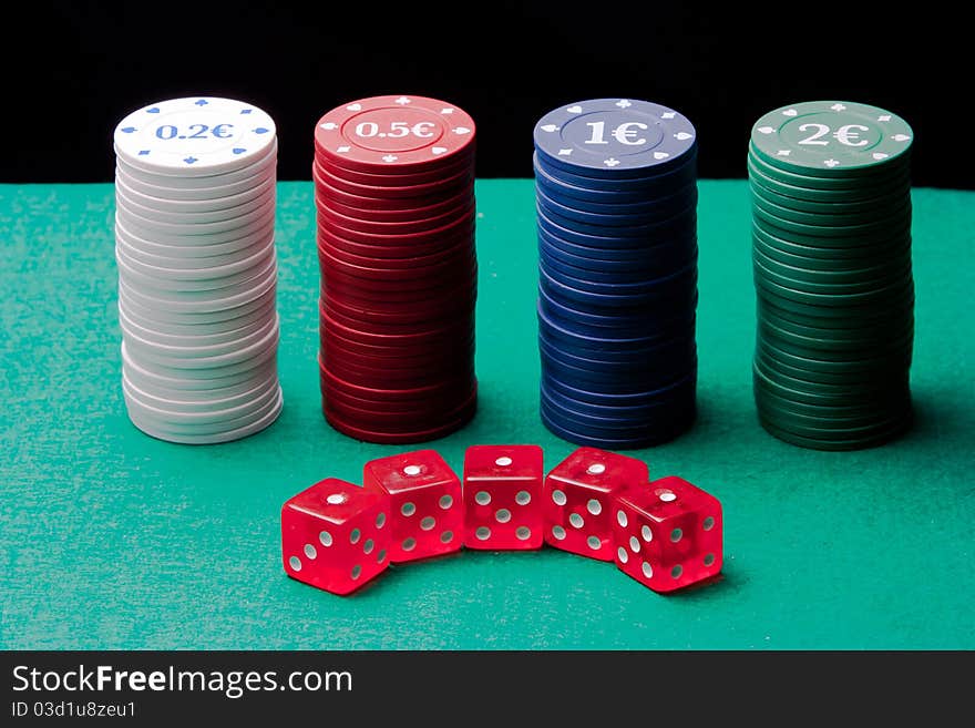 A group of dice and poker chips on a black background.