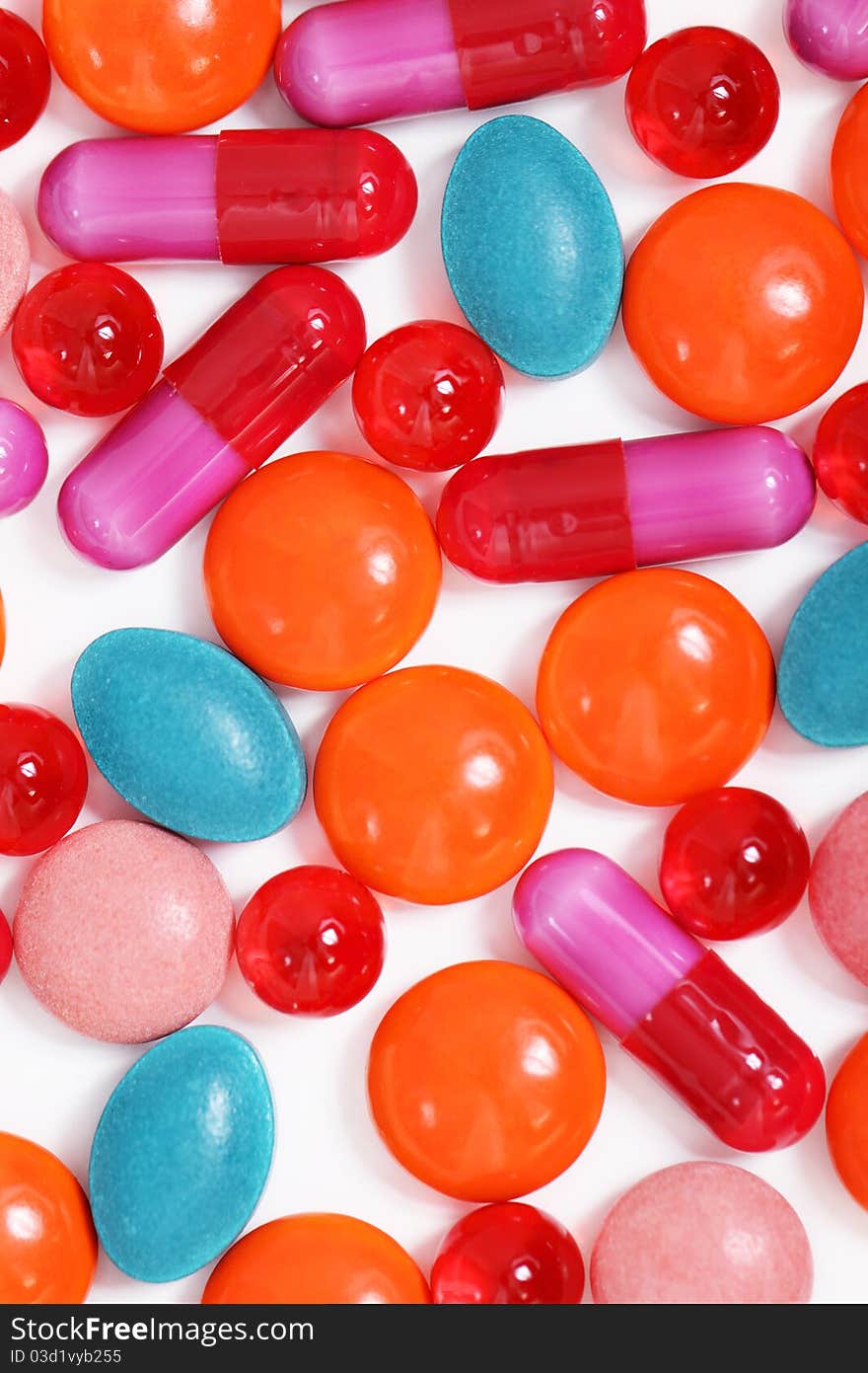 Milticolor pills and capsules on white background