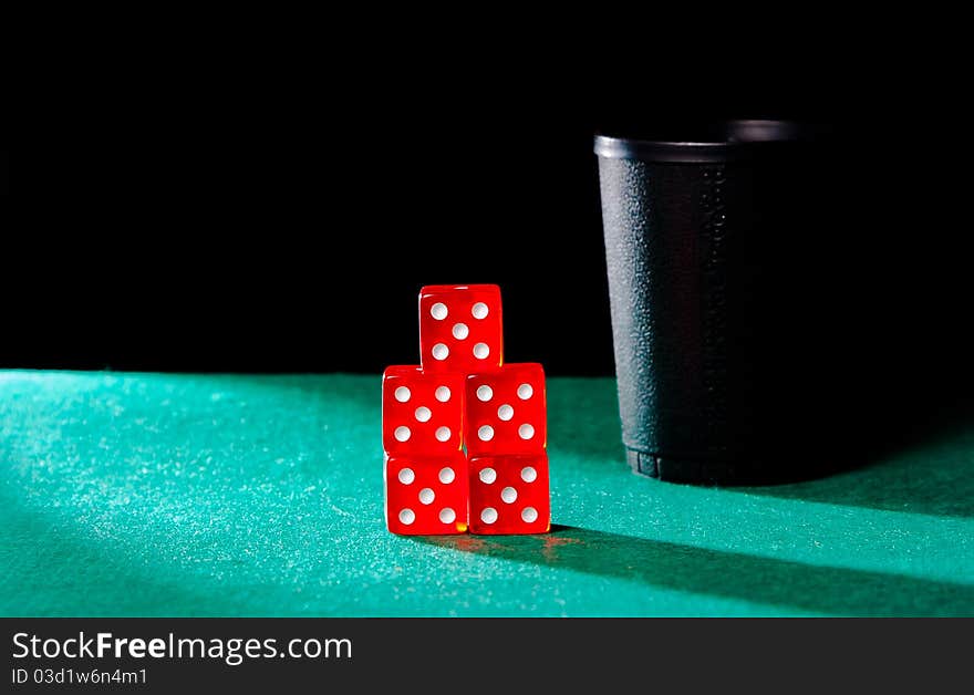 Poker with dice cube on playmat on black background