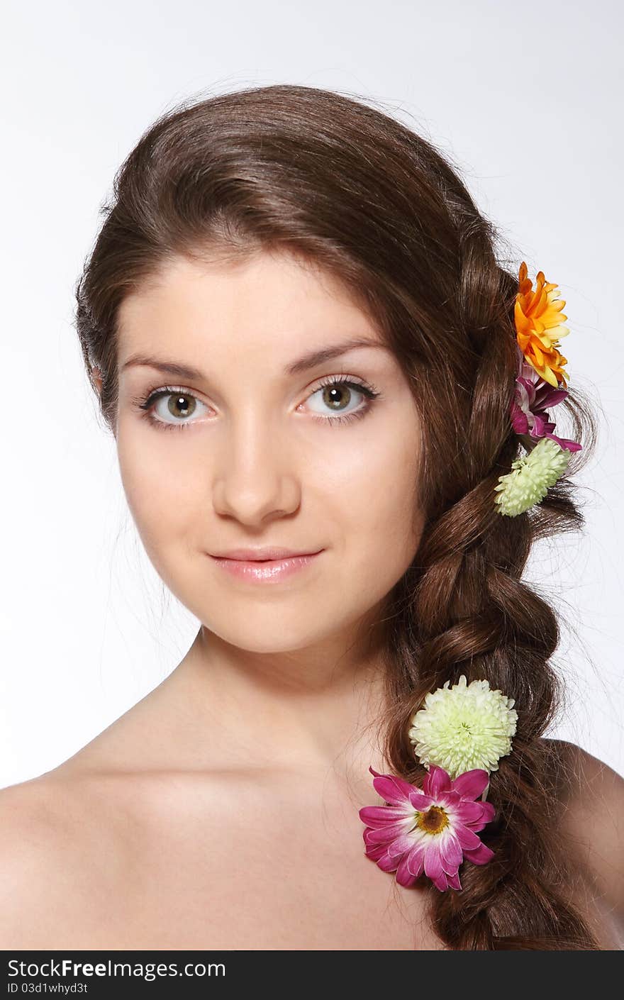 Portrait of the beauty young brunette girl with flowers in her hair