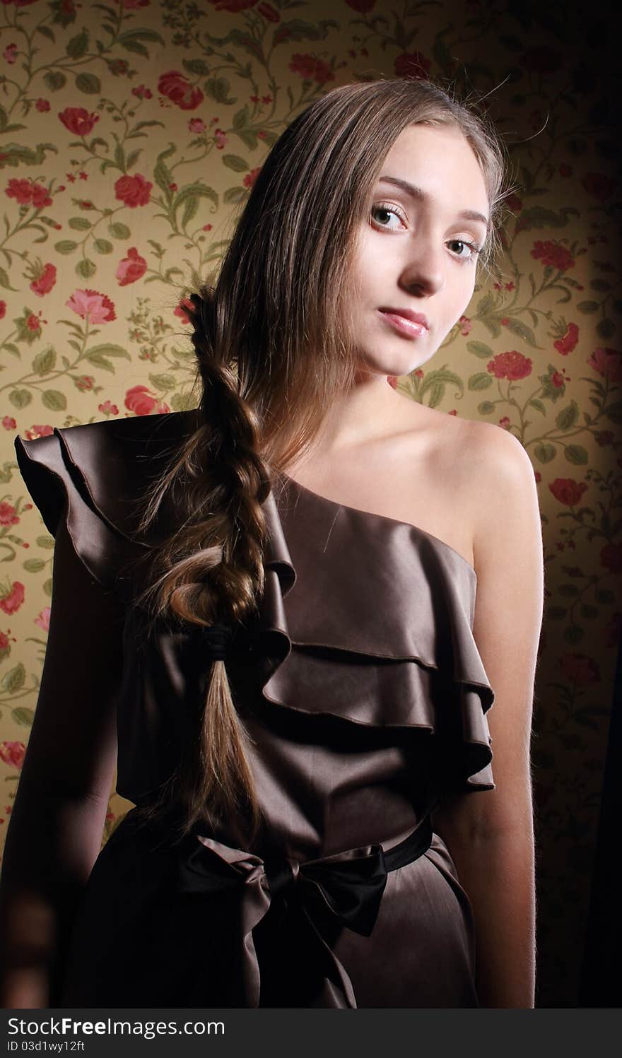 Portrait of the beauty young blond girl near the wall with roses