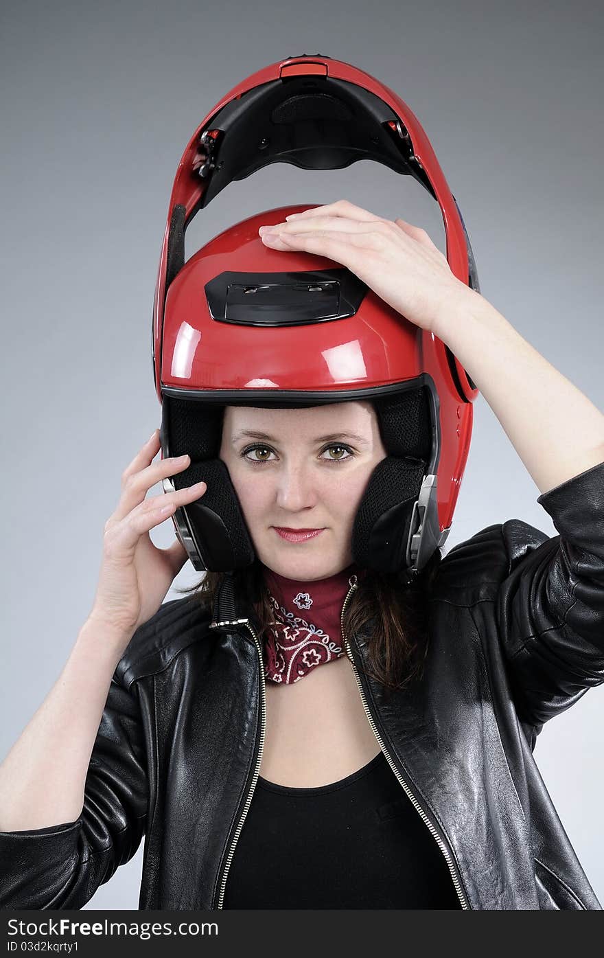 Young biker arranging helmet