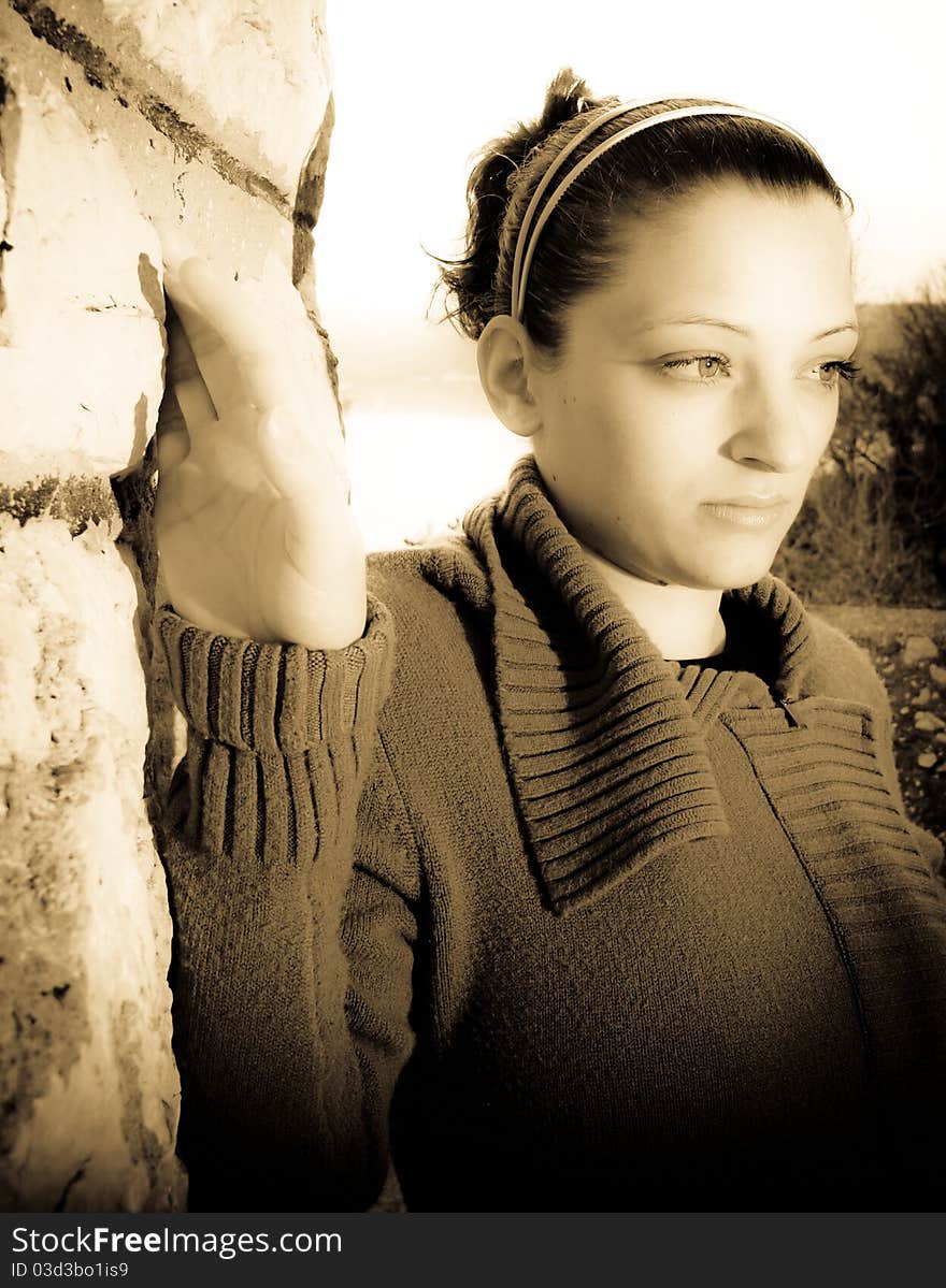 Portrait of beautiful young woman, pretty eyes and thoughtful look, holding by the wall