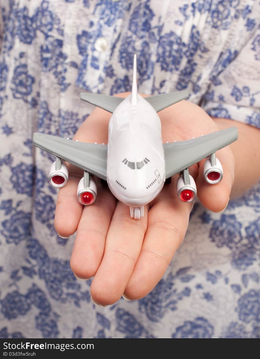 Woman hand with a small toy plane