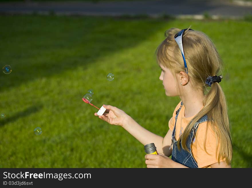 The girl plays with soap bubbles