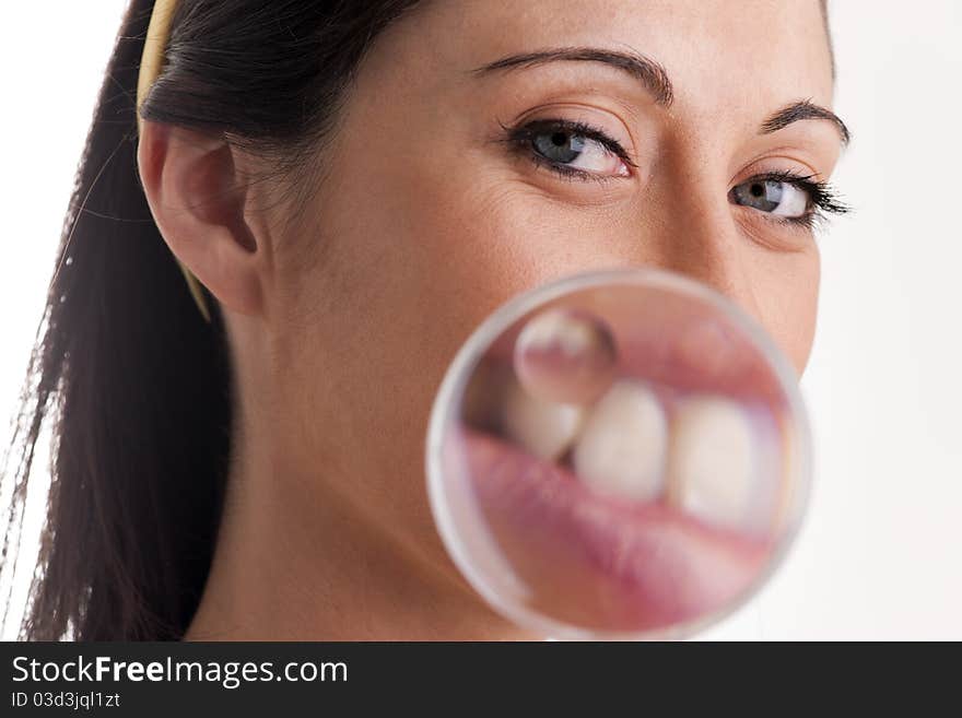 Woman with magnifying glass, enlarging her mouth