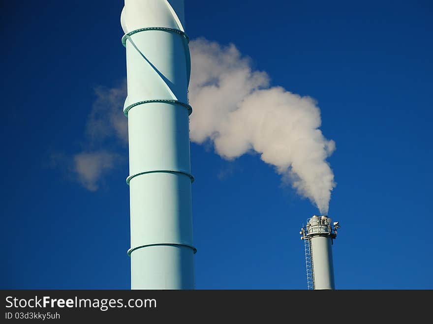 White smoke against blue sky. Urban Pollution