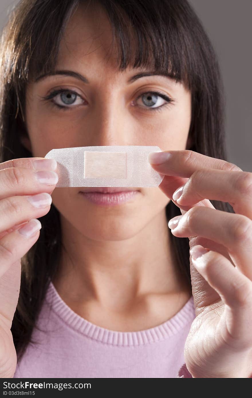 Woman applying bandage on nose