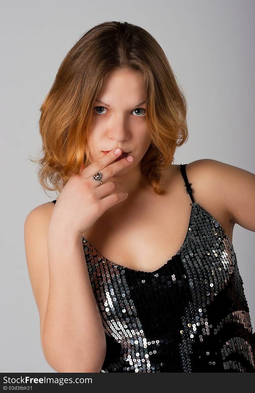 Lovely girl's portrait in black luxury dress in studio