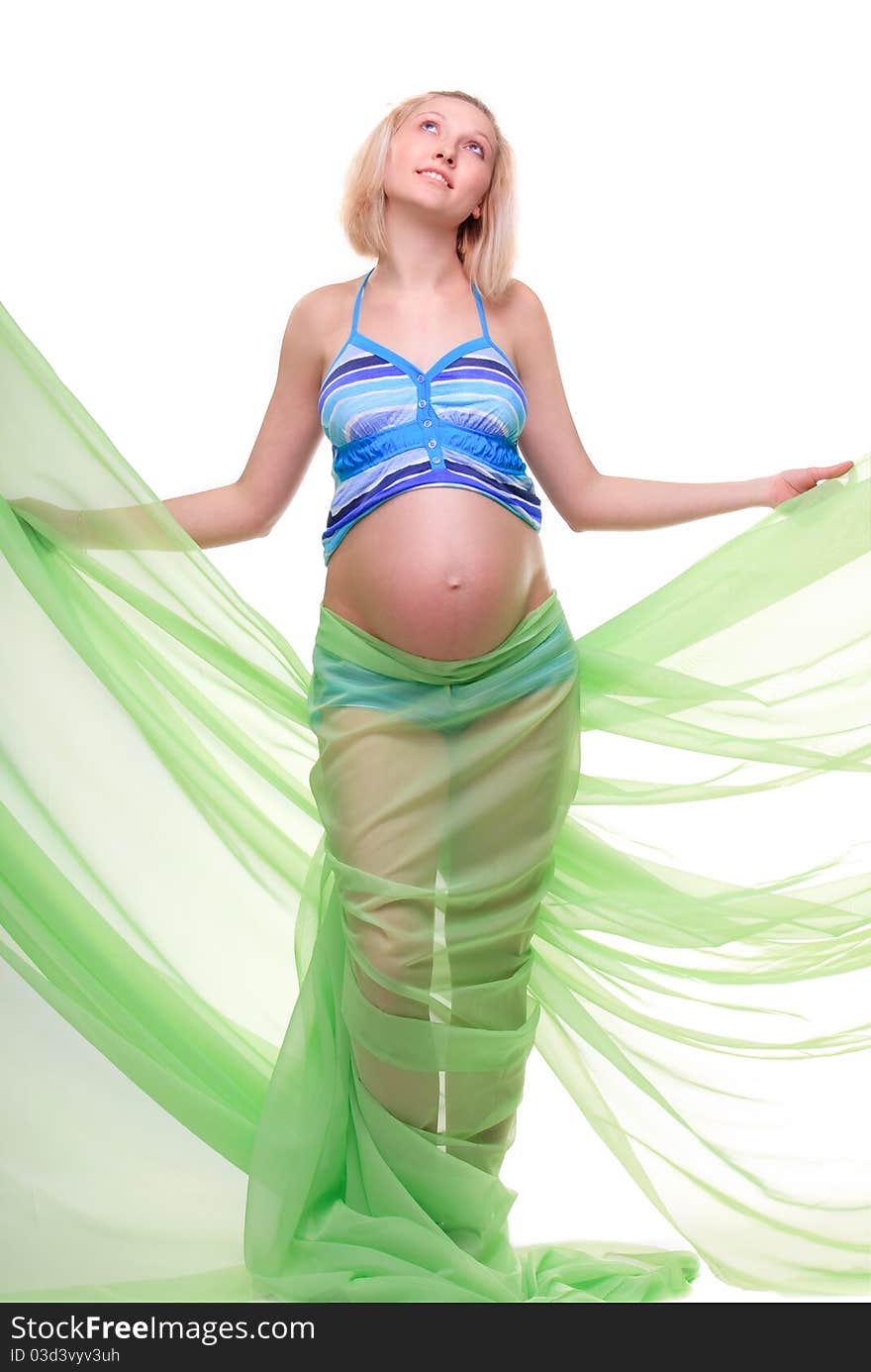 Beautiful young pregnant blonde woman with green transparent cloth in studio. Beautiful young pregnant blonde woman with green transparent cloth in studio