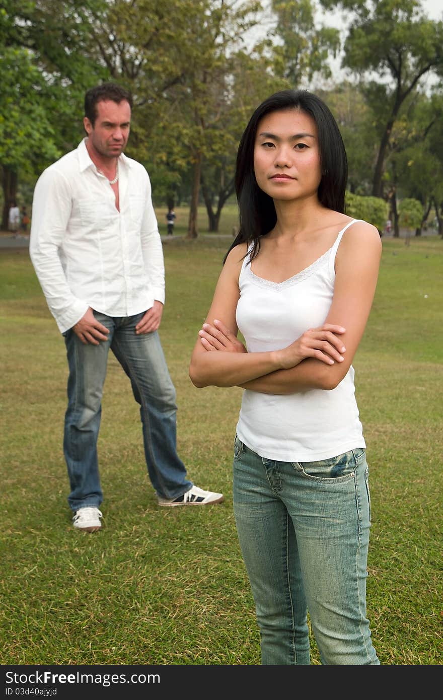 Woman do not look happy standing in front of man standing