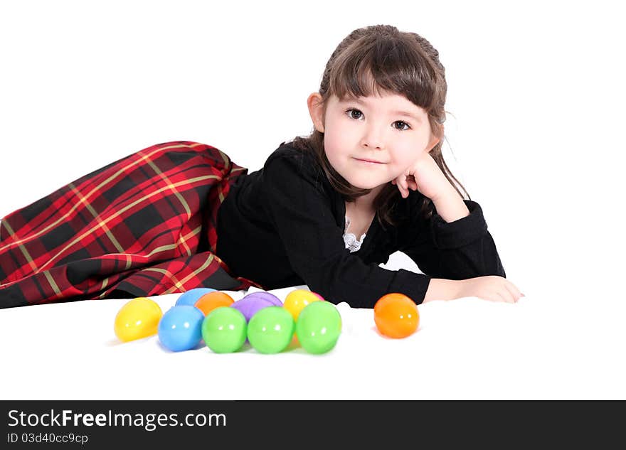 Adorable little girl lying down with easter eggs isolated on white