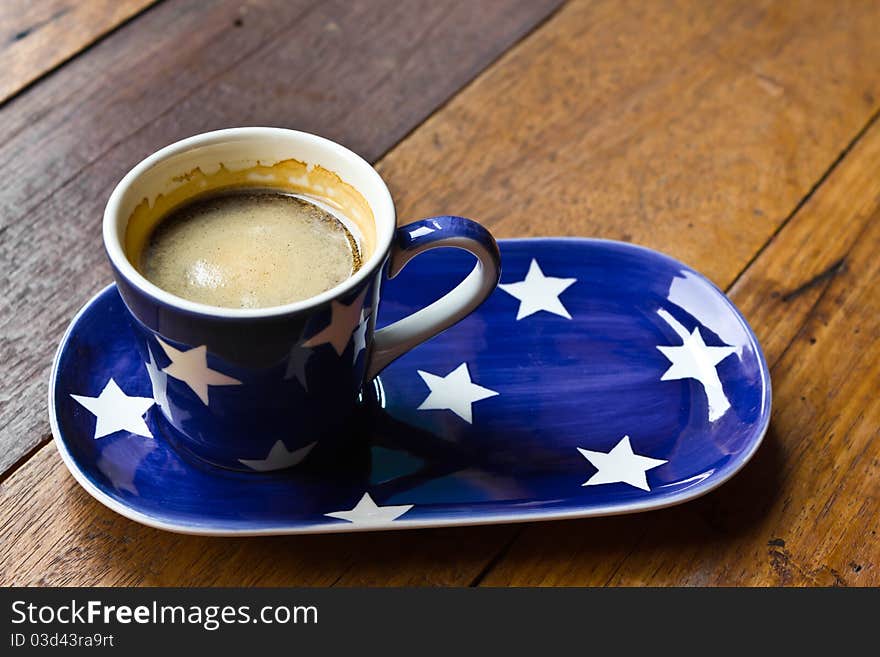 Cup of coffee and saucer on a wooden floor