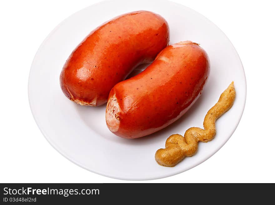 Boiled sausages with mustard on a white plate