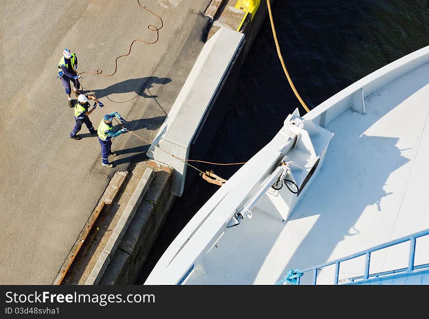 Maritime workers mooring a ship. Maritime workers mooring a ship