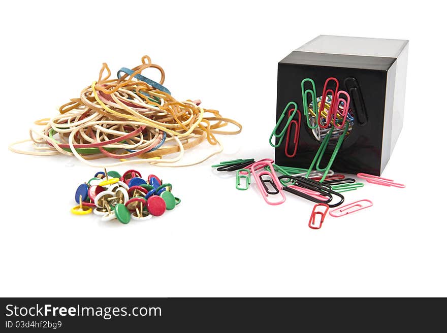 Rubber bands, paper clips and colored pins on white background. Rubber bands, paper clips and colored pins on white background