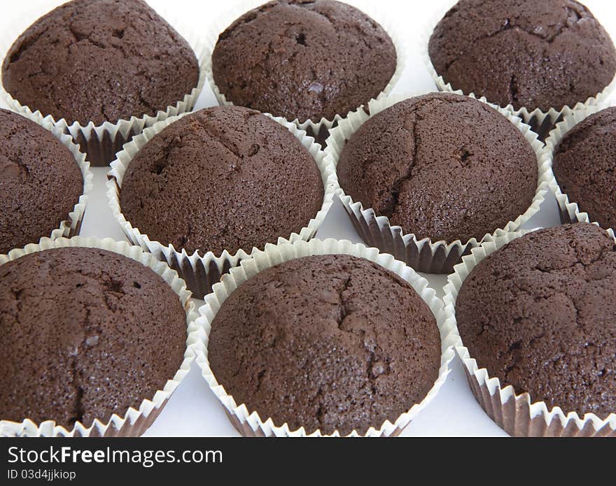 Chocolfte cake as background. Muffins