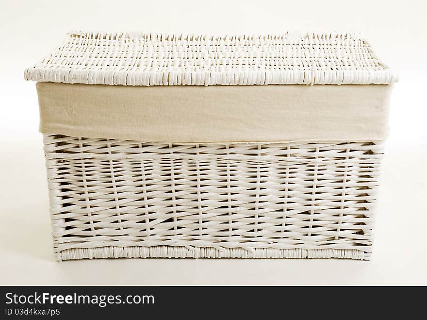 A closed white wicker toy basket isolated against a white background. A closed white wicker toy basket isolated against a white background