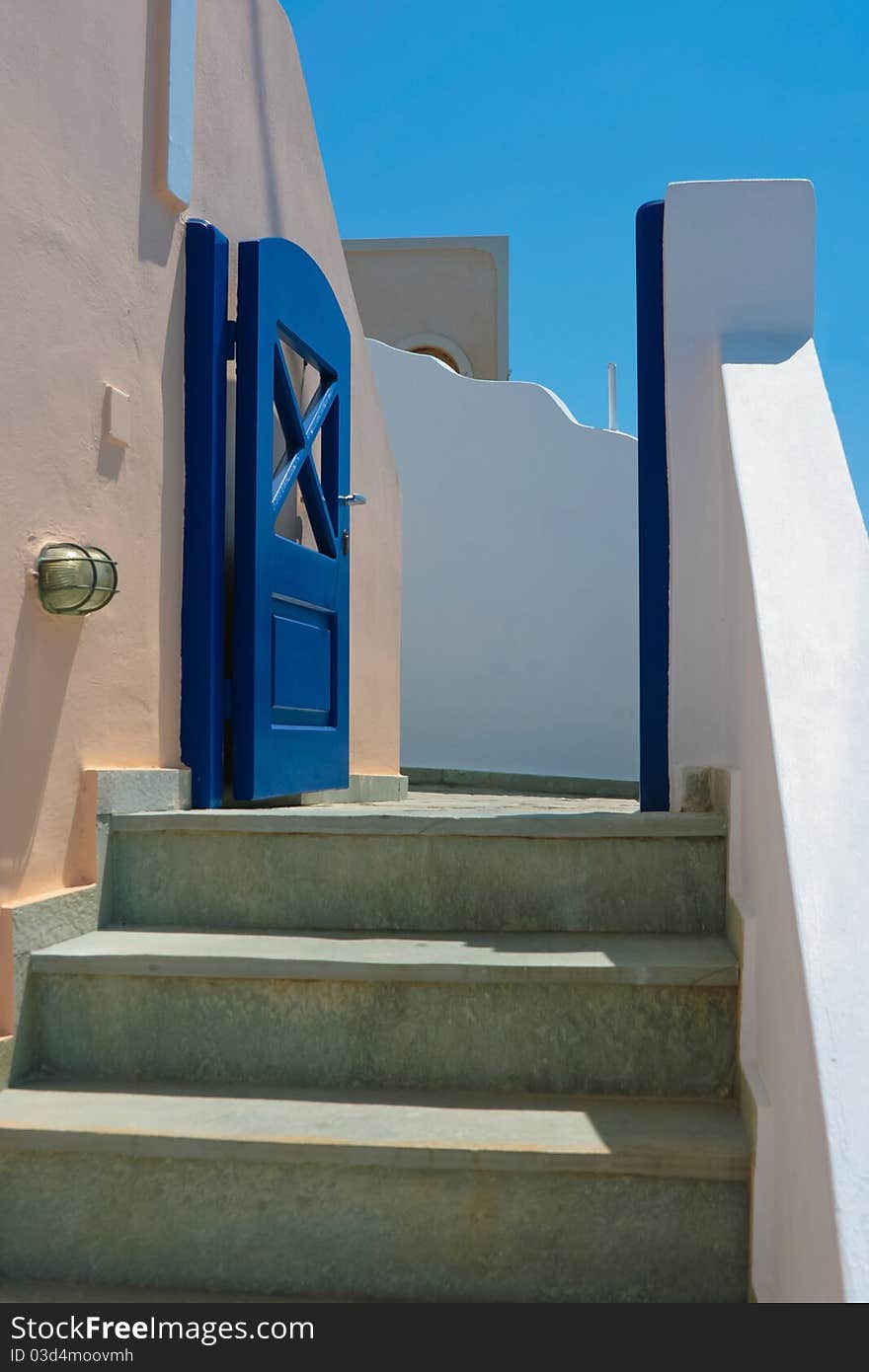 Quite street with three steps and old blue door on island of Santorini in Fira, Greece. Quite street with three steps and old blue door on island of Santorini in Fira, Greece.