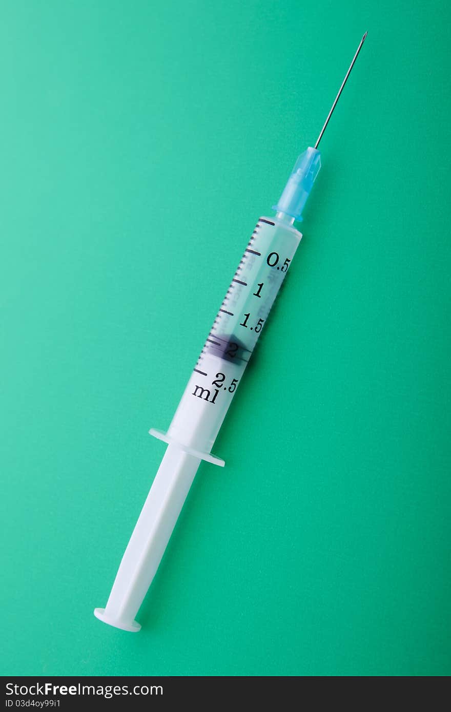 Medical syringe. First aid. On a green background.