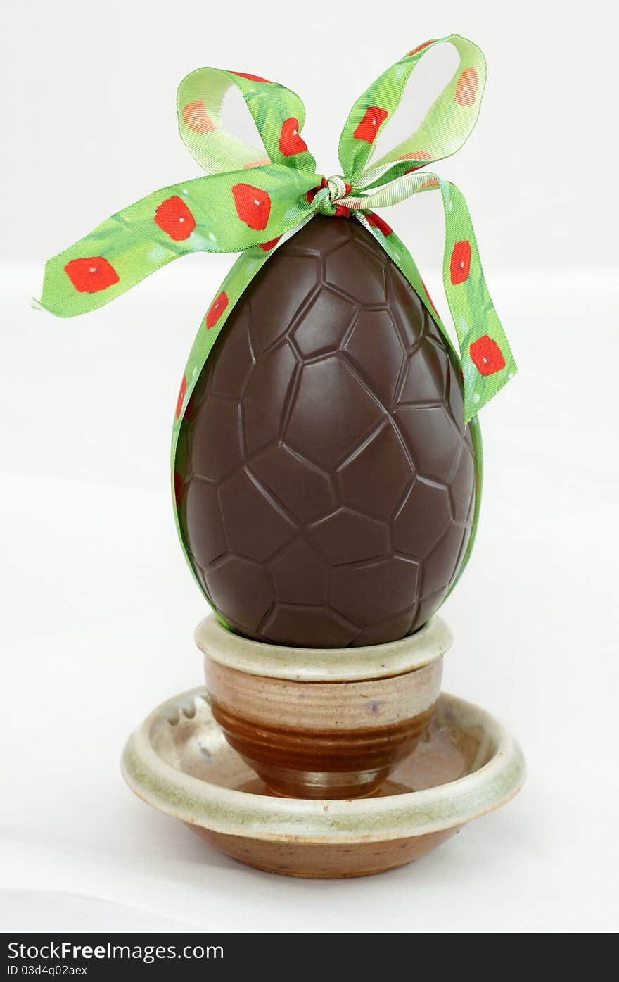 Dark chocolate Easter egg with a bow in a cup