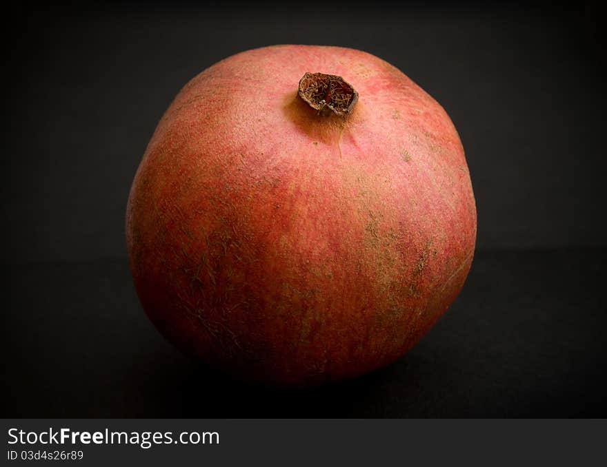 Perfect fresh pomegranate at dark background