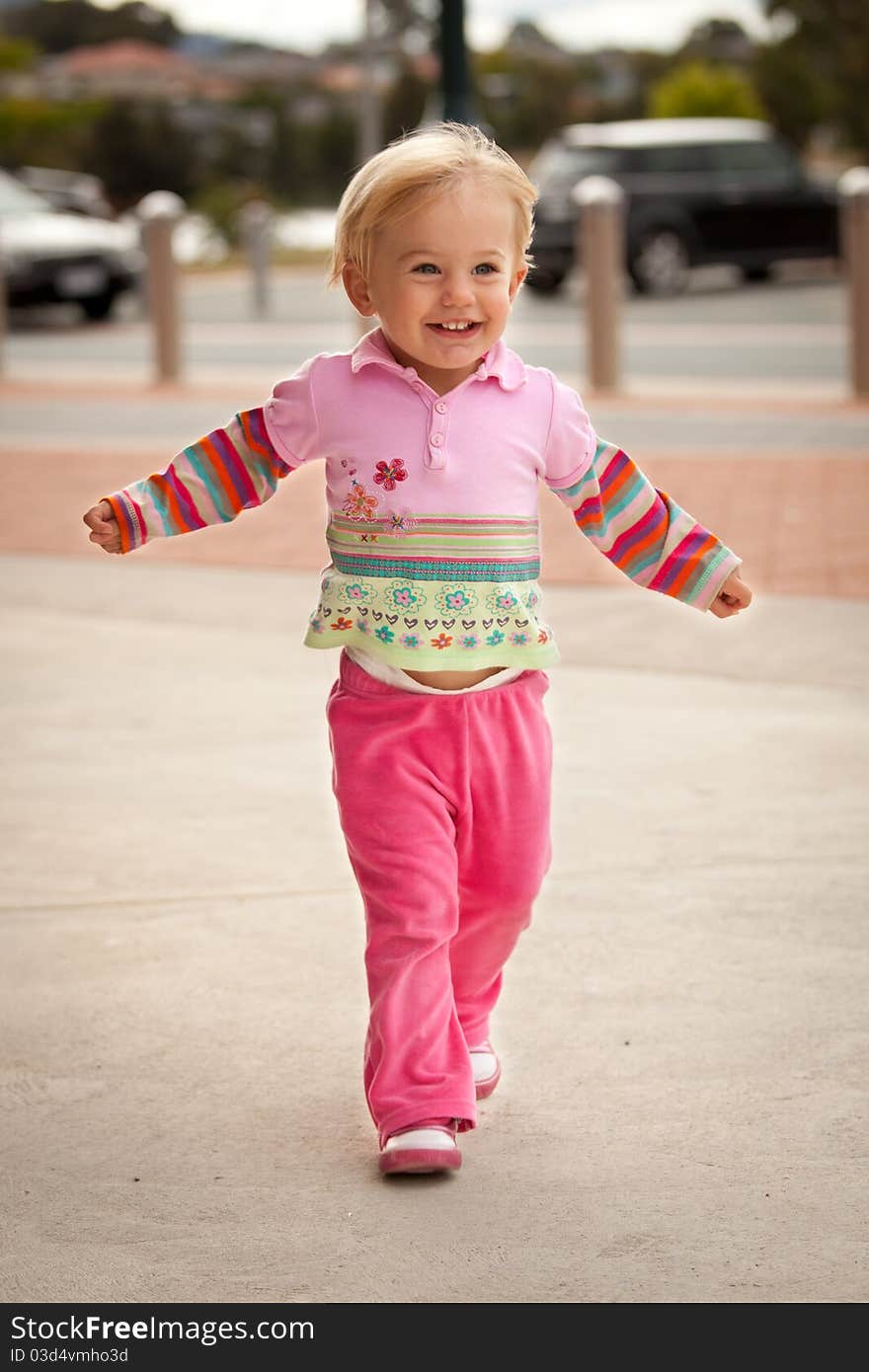 Little girl running towards camera with open arms. Little girl running towards camera with open arms