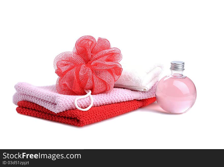 Stacked towels with red soap roses and bottle with soap gel on white background. Stacked towels with red soap roses and bottle with soap gel on white background