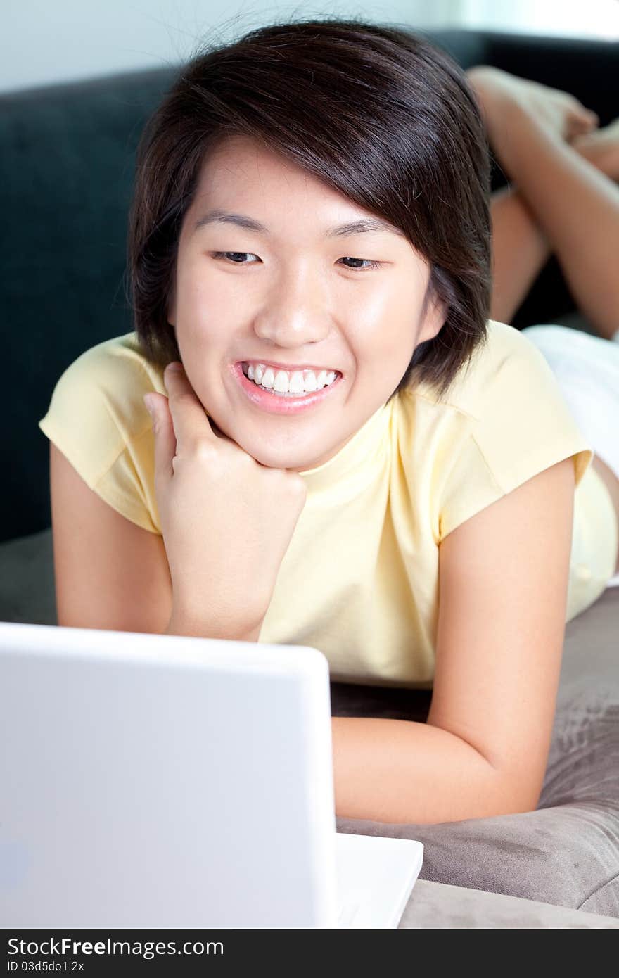 Young Asian Girl Browsing The Net On Couch